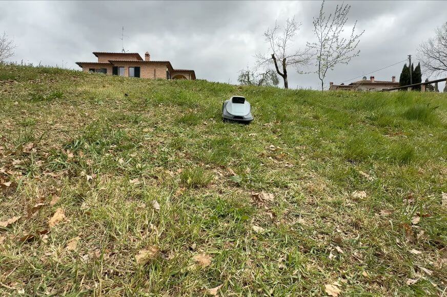 TerraMow V1000 Mähroboter fährt eine steile Böschung im Garten bergauf